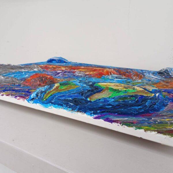 Opera materica di Valerio Zezur con rilievi e colori vivaci che rappresentano un paesaggio astratto